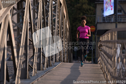 Image of african american woman running across the bridge