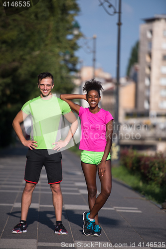 Image of portrait of young multietnic jogging couple ready to run