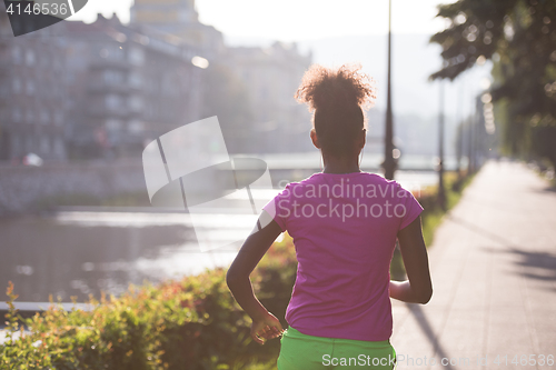 Image of african american woman jogging in the city