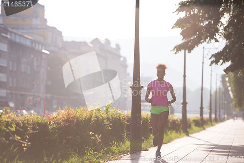 Image of african american woman jogging in the city