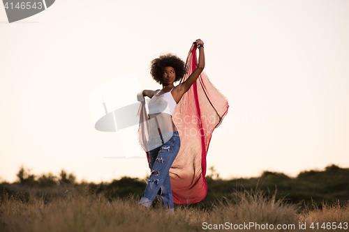 Image of black girl dances outdoors in a meadow