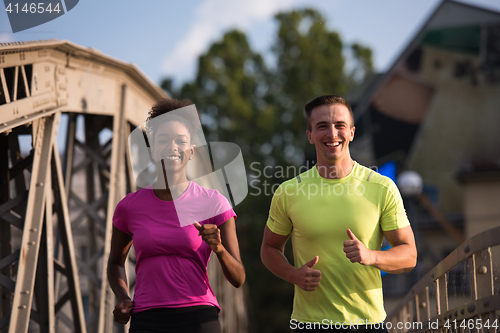 Image of multiethnic couple jogging in the city
