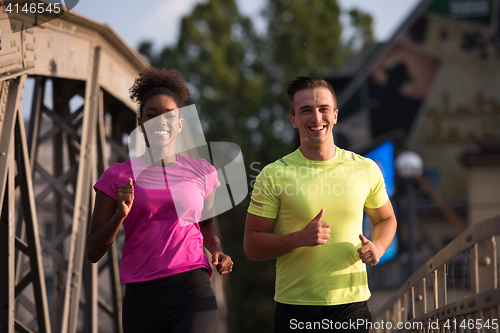 Image of multiethnic couple jogging in the city