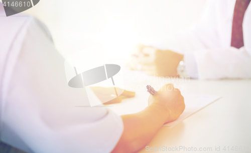 Image of close up of doctor taking notes at hospital