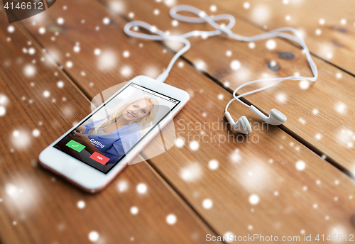 Image of close up of smartphone and earphones on wood