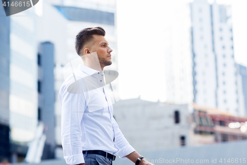 Image of young man walking along city street