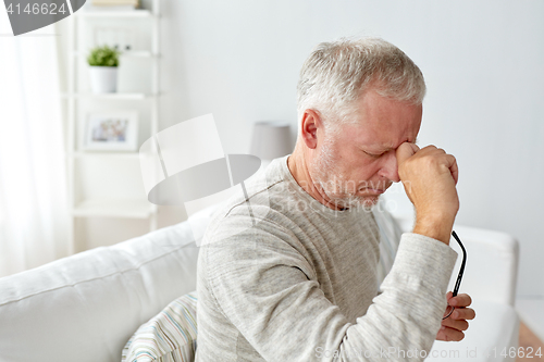 Image of senior man suffering from headache at home