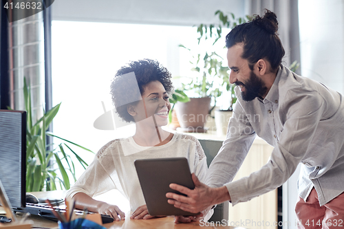 Image of happy creative team with tablet pc in office