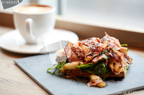 Image of prosciutto ham salad on stone plate at restaurant