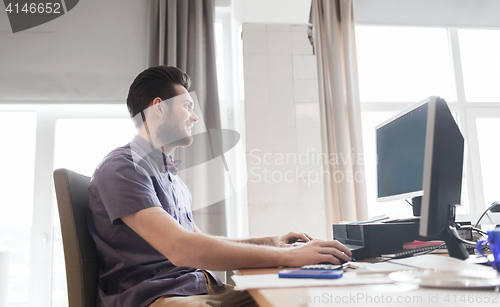 Image of happy creative male office worker with computer