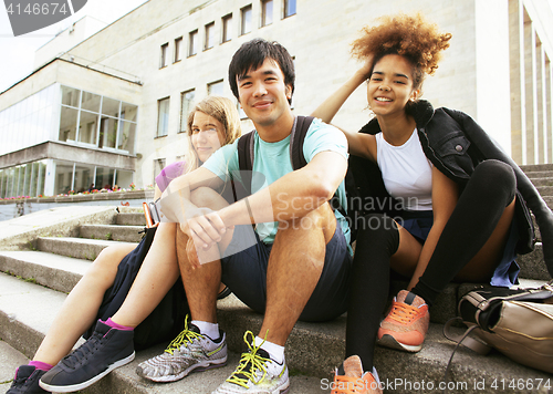 Image of cute group of teenages at the building of university with books 