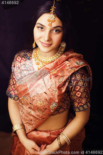 Image of beauty sweet real indian girl in sari smiling on black backgroun