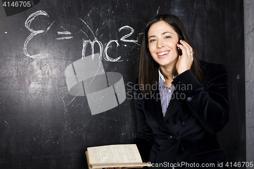 Image of portrait of happy cute student in classroom at blackboard back t