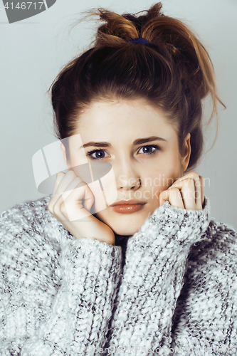 Image of young pretty woman in sweater and scarf all over her face, winte