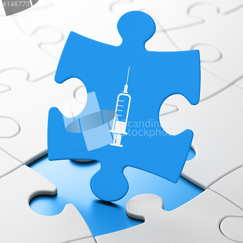 Image of Medicine concept: Syringe on puzzle background