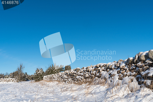 Image of Snow covered stone wall from a low perspective