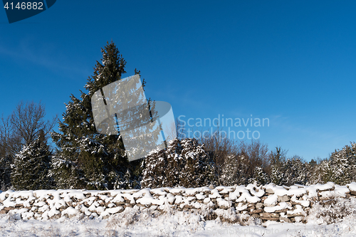 Image of Snow covered stone wall and a blue sky