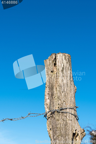 Image of Weathered old post with barbwire