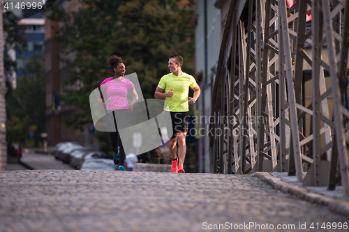 Image of multiethnic couple jogging in the city