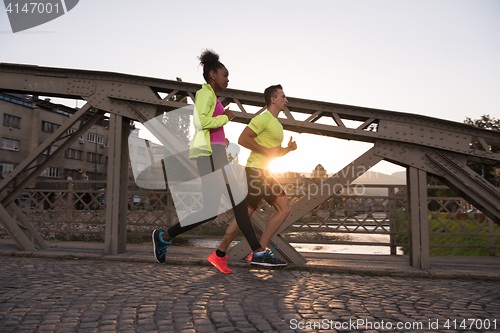 Image of young multiethnic couple jogging in the city