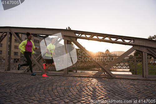 Image of young multiethnic couple jogging in the city