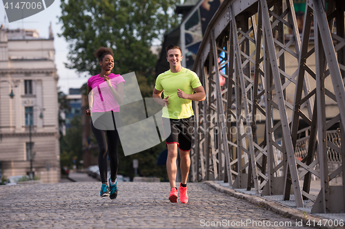 Image of multiethnic couple jogging in the city