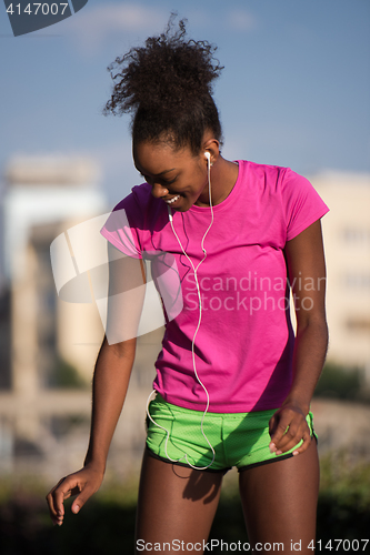 Image of young african american woman running outdoors