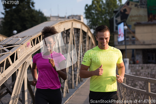 Image of multiethnic couple jogging in the city