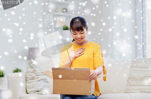 Image of happy asian young woman with parcel box at home