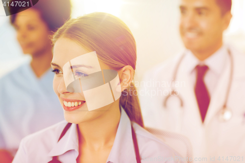 Image of happy doctor over group of medics at hospital