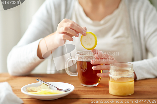 Image of close up of ill woman drinking tea with lemon