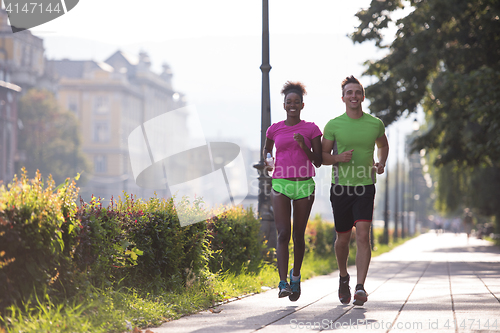 Image of young multiethnic couple jogging in the city