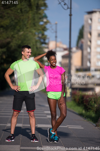 Image of portrait of young multietnic jogging couple ready to run