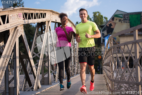 Image of multiethnic couple jogging in the city