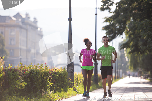 Image of young multiethnic couple jogging in the city