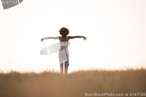 Image of young black girl dances outdoors in a meadow