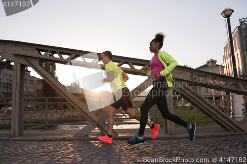 Image of young multiethnic couple jogging in the city