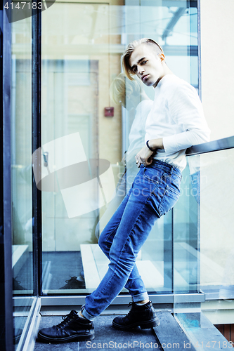 Image of young modern hipster guy at new building university blond fashio