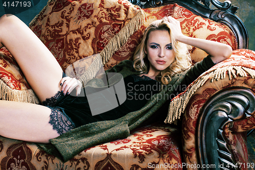 Image of Photo of sexy blonde young girl looking at camera, smiling. very slim in luxury interior