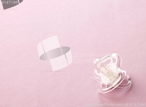 Image of transparent pacifier on pink background