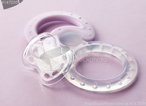 Image of transparent pacifier on pink background