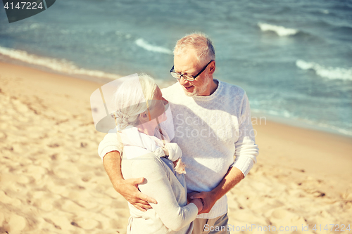 Image of happy senior couple hugging on summer beach