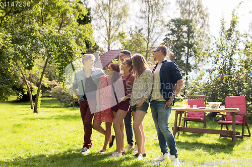 Image of happy teenage friends talking at summer garden