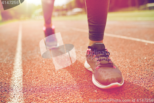 Image of close up of woman feet running on track from back