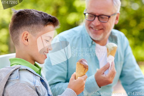 Image of old man and boy eating ice cream at summer park