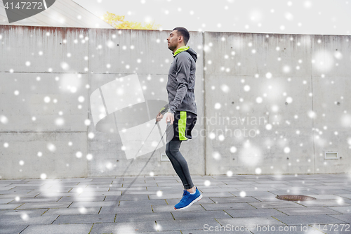 Image of man exercising with jump-rope outdoors