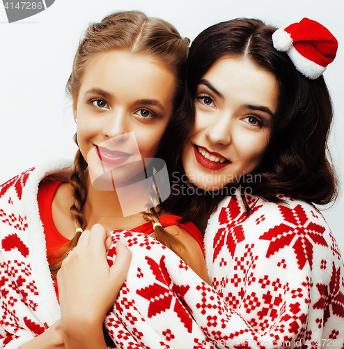 Image of young pretty happy smiling blond and brunette woman girlfriends on christmas in santas red hat and holiday decorated plaid, lifestyle people concept