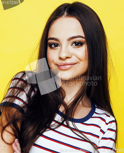 Image of young pretty teenage woman emotional posing on yellow background, fashion lifestyle people concept