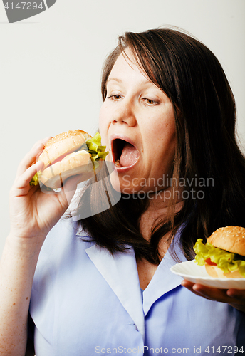 Image of fat white woman having choice between hamburger and salad close 