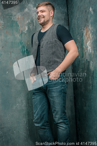 Image of Portrait of smiling happy man standing in studio